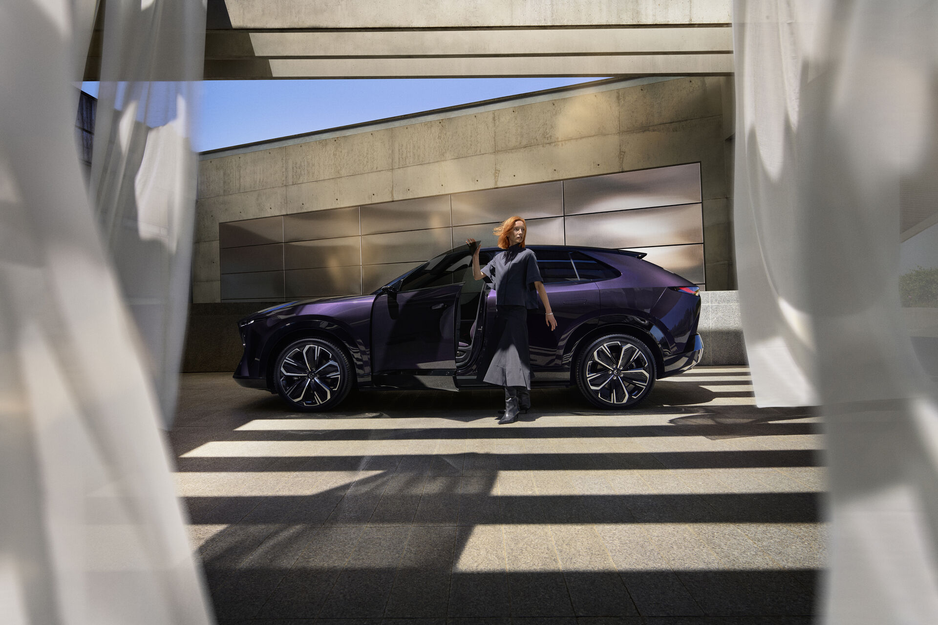 Mazda CX-6e vor moderner Architektur